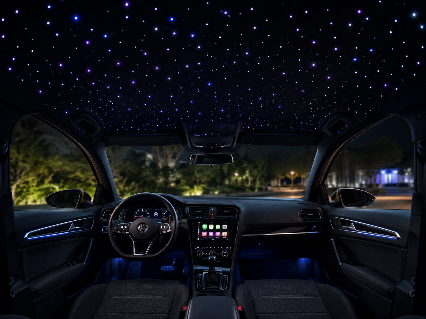 Interior de un coche de noche con el techo estrellado de fibra óptica encendido e iluminación ambiental